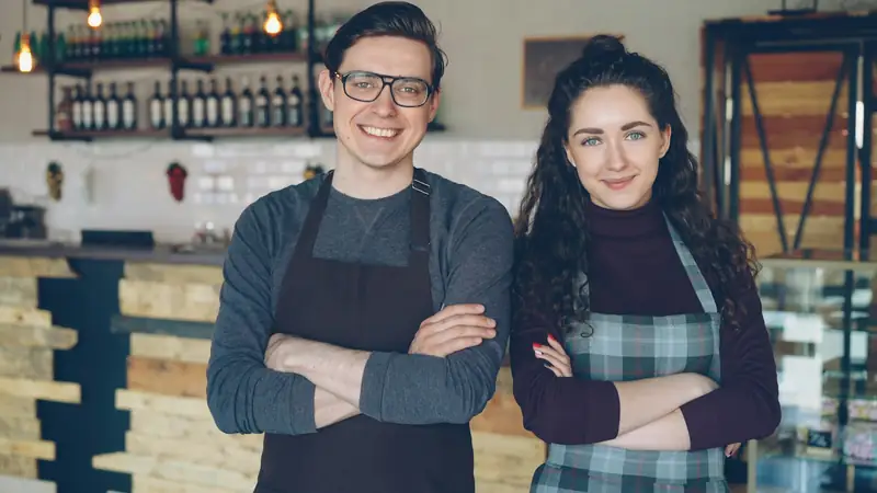 Commerçants souriants devant leur boutique